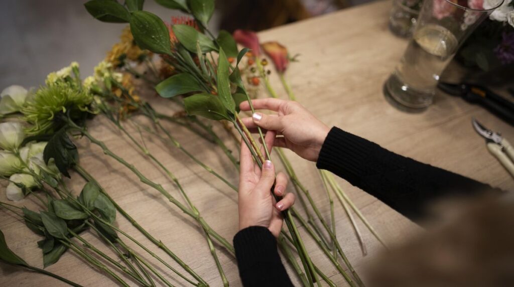 Florystka układa wiązankę z ciętych kwiatów